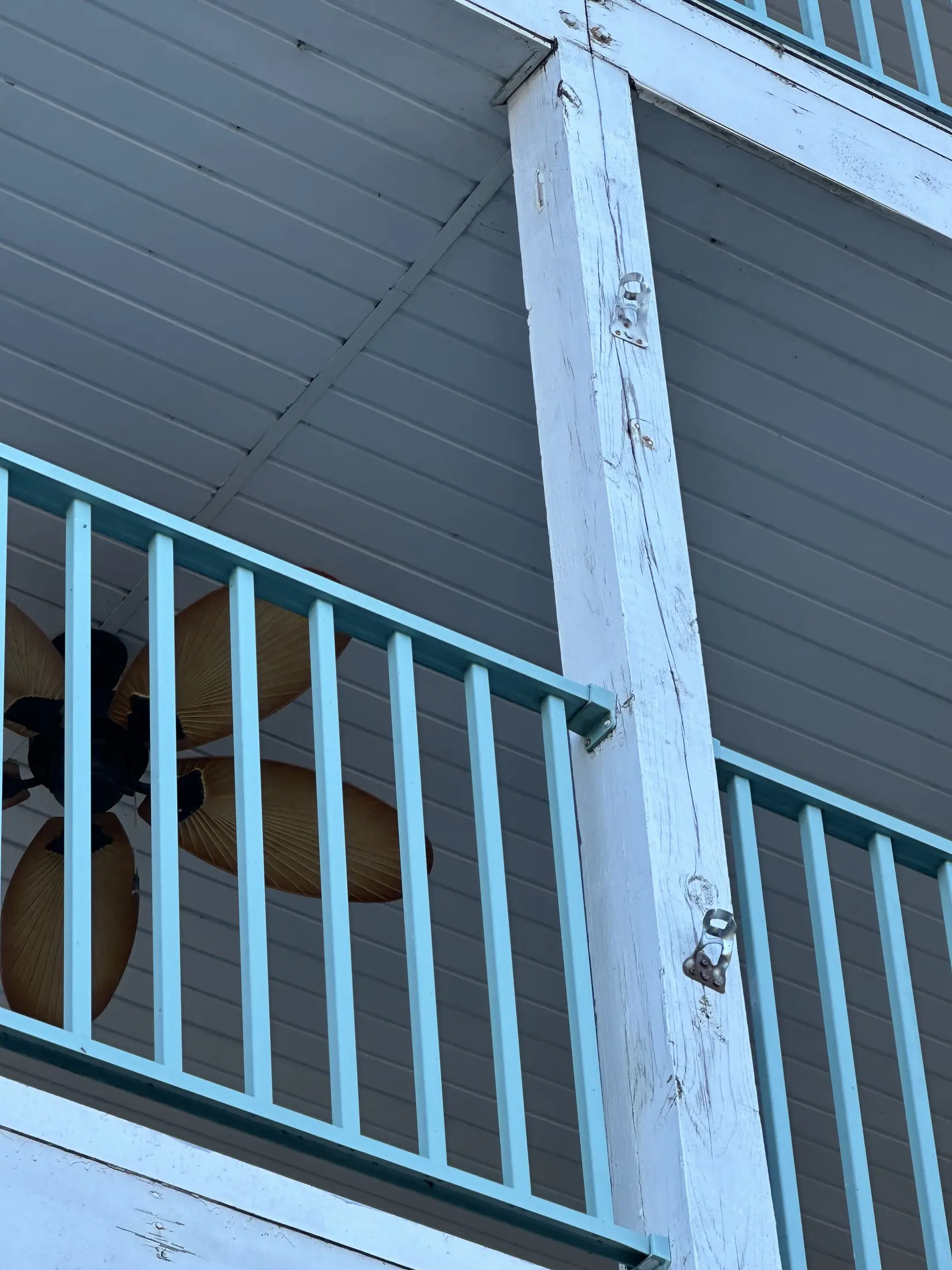 Dark exterior siding and a white condominium railing detail.