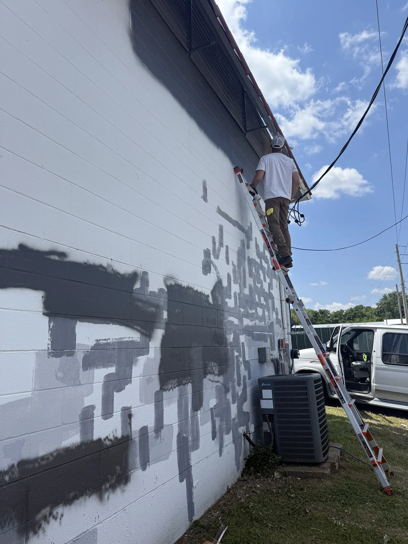 Commercial roof surface with areas of dark coating or patching.