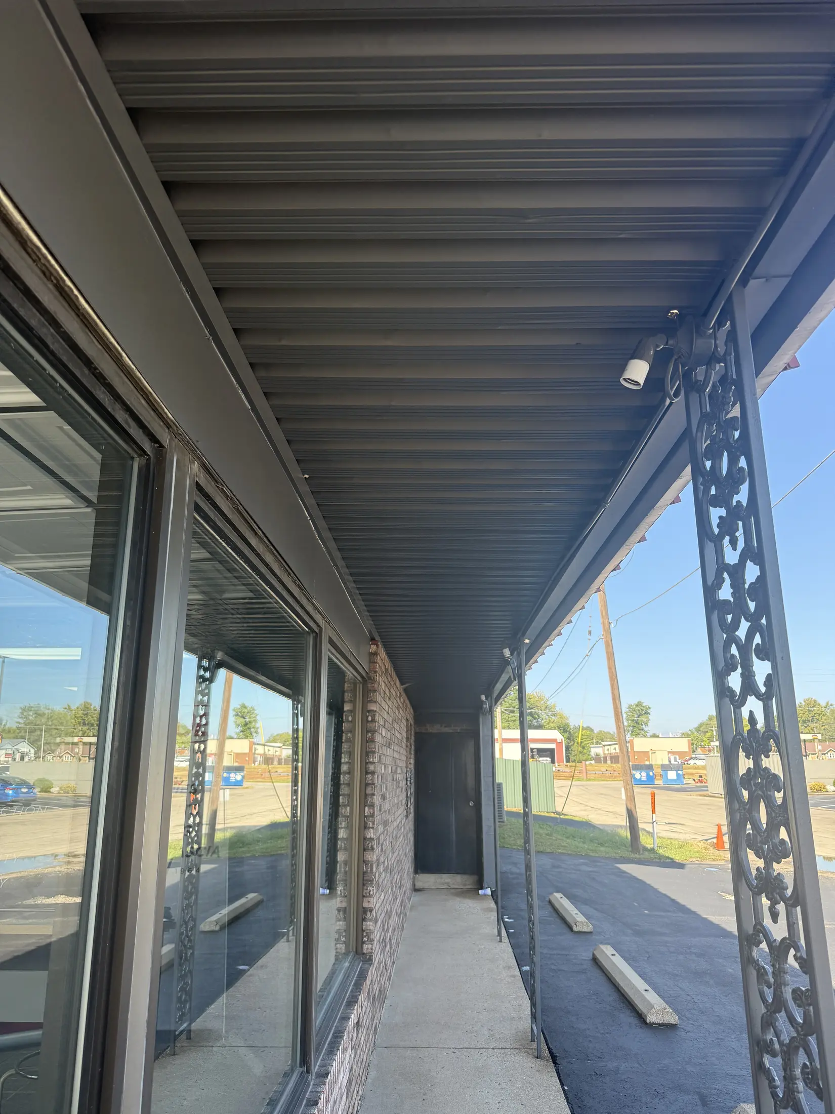 View beneath a commercial roof overhang beside a walkway.