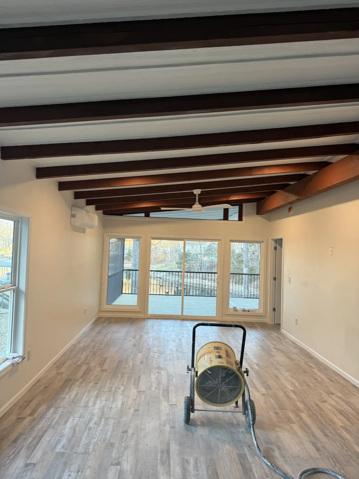 Lake Painters interior project with freshly refinished walls, exposed wood beams, and large windows.